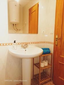 La salle de bains est pourvue d'un lavabo blanc et d'un miroir. dans l'établissement Casa Playa Lisa, à Santa Pola