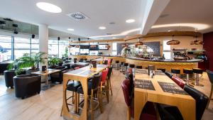 a restaurant with wooden tables and chairs and a bar at R&R Residenzen Ferienwohnungen in Mitterbach