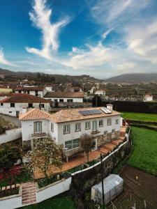 una vista aerea di una casa bianca di Coliving The VALLEY Portugal private bedrooms with a single or a double bed, a shared bedroom with a bed and futons, shared bathrooms and a coworking space open 24-7 a Vale de Cambra