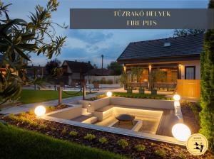 a garden with a fire pit in front of a house at Anser Vendégházak in Poroszló