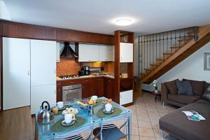Il comprend une cuisine et un salon avec une table et un canapé. dans l'établissement IL BORGO 48 - Regarda Travel, à Bardolino