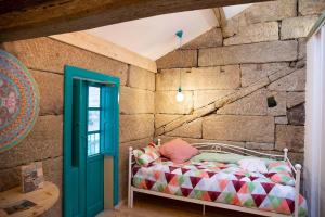 1 dormitorio con 1 cama en una pared de piedra en 4 Soles en Puente Caldelas