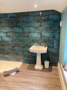 a bathroom with a sink and a brick wall at Church Farm in Gillingham