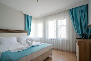 River Park Residence Lara في أنطاليا: غرفة نوم بسرير والستائر زرقاء