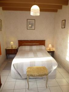 een slaapkamer met een groot bed en 2 tafels bij Le gite du porche in Saint-Georges-lès-Baillargeaux