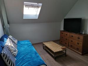 a bedroom with a bed and a tv and a dresser at Le Clos des Tempêtes in Étretat
