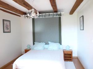 1 dormitorio con cama blanca y ventana en La maison d'angel, en Coussay-les-Bois