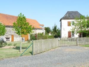 una cerca frente a una casa con un patio en La maison d'angel, en Coussay-les-Bois