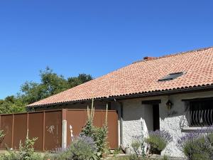 a house with a red roof and a fence at Le balét in Asnois