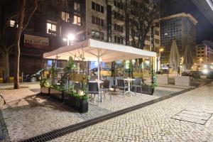 a restaurant with tables and chairs on a city street at night at Patria Hotel in Lisbon