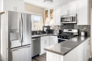 uma cozinha com armários brancos e um frigorífico de aço inoxidável em San Mateo 1br w pool wd easy access to 101 SFO-1132 em San Mateo