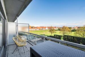 balkon ze stołem i 2 krzesłami w obiekcie La perle du Nord studio met meer, strand en zwembad w mieście Knokke-Heist
