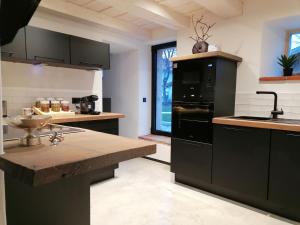 cocina con electrodomésticos negros y ventana grande en Geigelstein Chalets, en Unterwossen