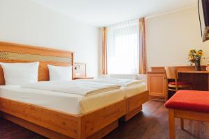 a bedroom with a large bed with a wooden headboard at Bräuhaus Ummendorf in Ummendorf-Biberach