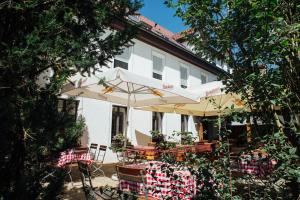 a table and chairs with an umbrella in front of a building at Bräuhaus Ummendorf in Ummendorf-Biberach