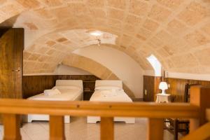 two beds in a room with a stone ceiling at La Casa dell'oste in Monopoli