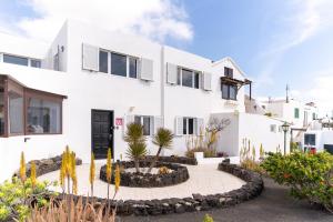 una casa bianca con un giardino di fronte di Casa Salinas del Mar a Guatiza