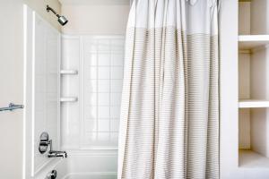 a bathroom with a shower curtain and a tub at Menlo Park 1BR w Lounge WD nr Caltrain SFO-993 in Menlo Park +21 photos