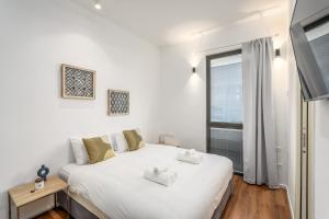 a bedroom with a large white bed and a window at Luxury 3BR on Frishman SEA u TLV in Tel Aviv