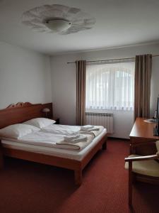Schlafzimmer mit einem Bett, einem Schreibtisch und einem Fenster in der Unterkunft U Juhasa Miętówka in Białka Tatrzańska