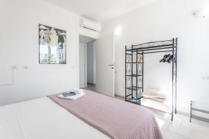 a white room with a bed and a mirror at Appartamenti Rocca 'Ja in Castelsardo