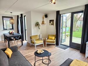 a living room with a couch and a table at 7 person House with swing, firepit, hammock, garden, swimming lake, child friendly, in- and outside playground, and great coffee in Ewijk