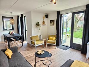 een woonkamer met een bank en een tafel bij 7 person House with swing, firepit, hammock, garden, swimming lake, child friendly, in- and outside playground, and great coffee in Ewijk