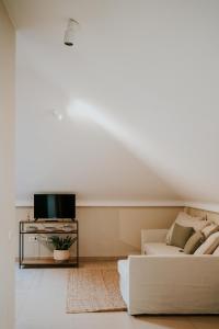 a white living room with a couch and a tv at Apartamentos Poniente - Mares in Torre del Mar +27 photos