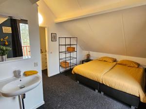 a bedroom with a bed and a sink at 7 person House with swing, firepit, hammock, garden, swimming lake, child friendly, in- and outside playground, and great coffee in Ewijk