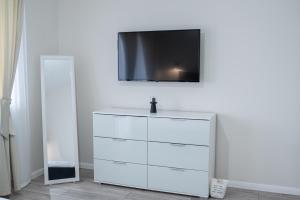 a white dresser with a television on top of it at TEILOR Apartments 3 in Floreşti