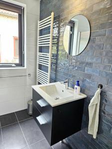 a bathroom with a sink and a mirror at 7 person House with swing, firepit, hammock, garden, swimming lake, child friendly, in- and outside playground, and great coffee in Ewijk +21 photos