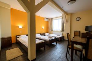 a room with two beds and a table and a cross at Winnica Maria Anna in Wyżne