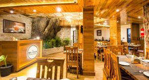 a restaurant with wooden tables and chairs and a bar at Valmere Lungta Boutique Hotel & Spa in Darjeeling