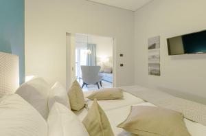 a white bedroom with two beds with pillows at Ferienwohnung Ostseeblick mit Balkon in Wustrow