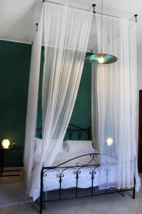 a bedroom with a canopy bed with white curtains at Tenuta Piana 2 con accesso diretto al mare in Caronia