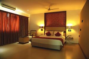a bedroom with a large bed with a red wall at SRM Hotel in Tuticorin +24 photos