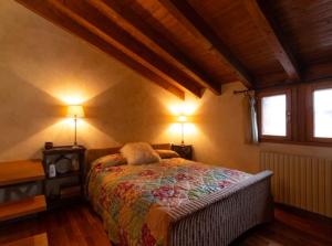 a bedroom with a bed with two lamps and two windows at Bombonera romántica con vistas a Grandvalira in El Tarter