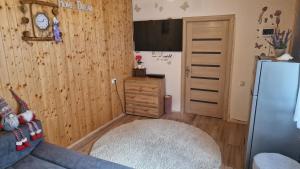 a kitchen with wooden walls and a refrigerator in a room at D&D ROOM in Bucharest
