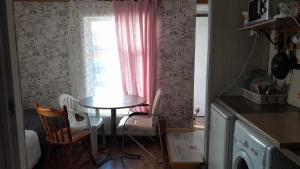 a table and chairs in a kitchen with a window at Comfort flat & parking Gertrudes Street Riga in Riga