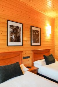 パラス・デ・レイにあるAlda Palas de Reiのキャビン内のベッド2台 壁に2枚の写真が飾られています。