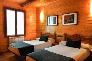 帕拉斯德丽Alda Palas de Rei的一间木墙房间里有两张床