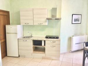 錫納倫加的住宿－Appartamento Turistico FRAU A，厨房配有水槽和炉灶 顶部烤箱