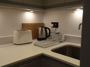 eine Küchentheke mit Kaffeemaschine und Toaster in der Unterkunft Stylish Studio Apartment, ensuite, kitchenette in Twickenham