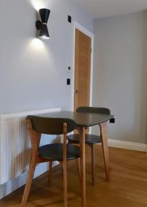 una mesa y dos sillas, una mesa y una luz en Stylish Studio Apartment, ensuite, kitchenette en Twickenham