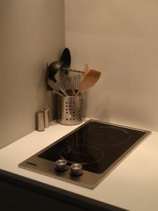 a kitchen counter with a black sink and utensils at Stylish Studio Apartment, ensuite, kitchenette in Twickenham