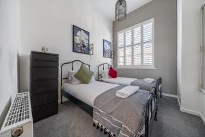 ein Schlafzimmer mit zwei Betten und einem Fenster in der Unterkunft Corner Lodge Bishophill York - FREE PARKING in York