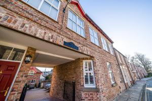 ein Backsteingebäude mit einer roten Tür an einer Straße in der Unterkunft Corner Lodge Bishophill York - FREE PARKING in York