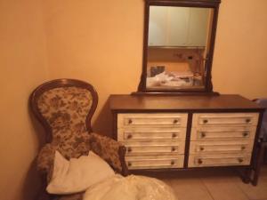 un miroir assis au-dessus d'une commode avec une chaise dans l'établissement Casa Garage, à Roccatederighi