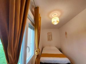 a small bedroom with a bed and a window at Maison cosy 3 chambres à la campagne in LʼAbergement-Sainte-Colombe
