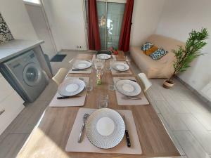 a dining room table with white plates and silverware at Maison cosy 3 chambres à la campagne in LʼAbergement-Sainte-Colombe +15 photos